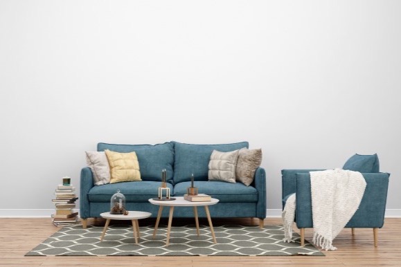 Teal sofa and armchair with a patterned rug.