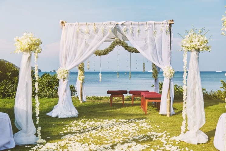 Beach wedding arch draped in white fabric.